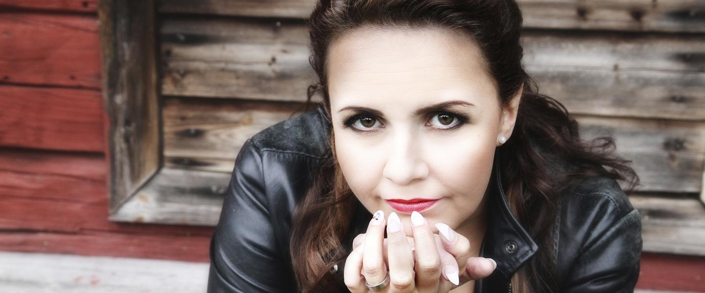 tangokuningatar Johanna Debreczeni nojaa leualla käsiin vanhan aitan edustalla.