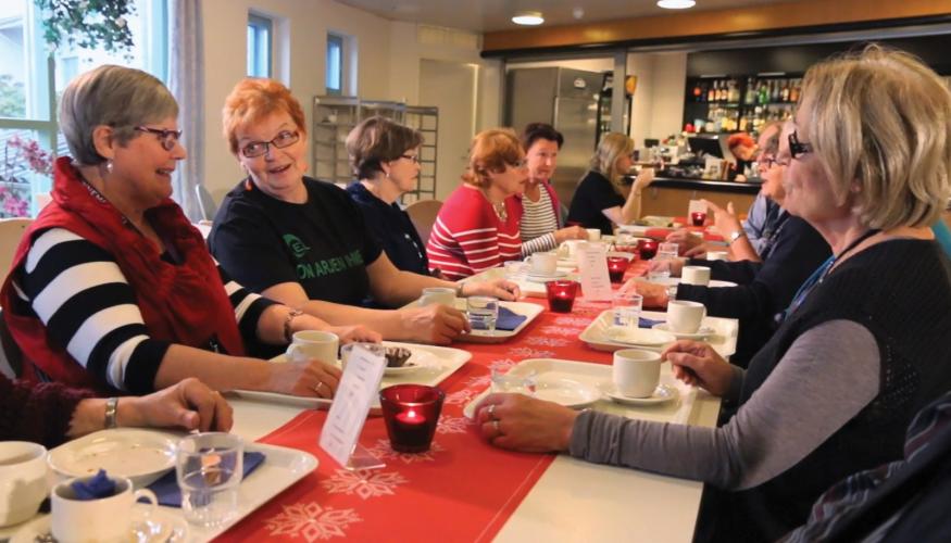 Ryhmä naisia kahvipöydässä keskustelemassa