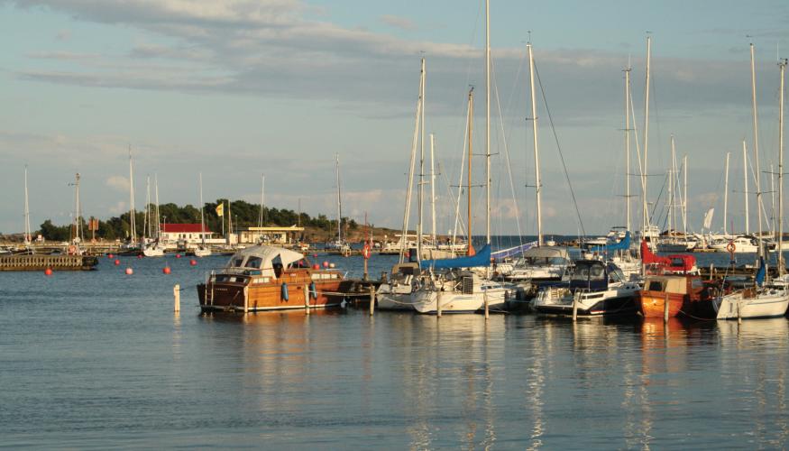 Purjeveneitä laiturissa auringon laskiessa Hangossa