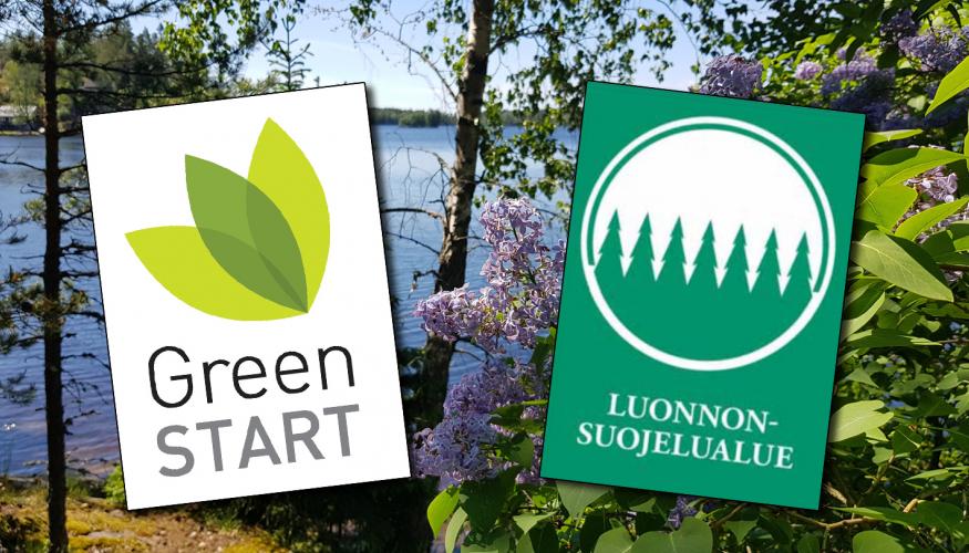 GreenStart- ja luonnonsuojelualuemerkki Lehmirannan lomakeskuksen järvimaisemassa otetun kuvan päällä.
